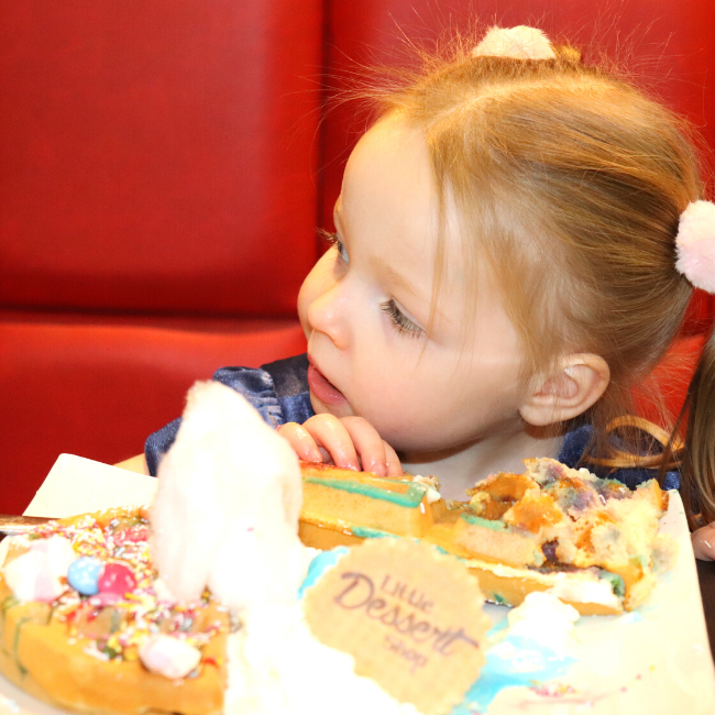 A child enjoying an Enchanted Unicorn waffle