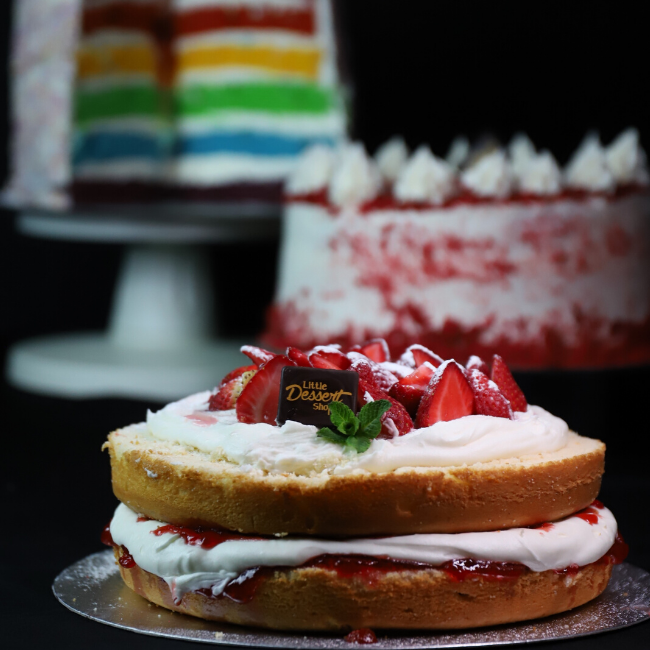 A strawberries and cream sponge cake with a Little Dessert Shop chocolate piece